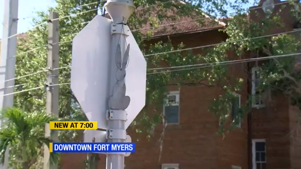 Real life photo of a news report, with a rabbit figure stuck on a stop sign.